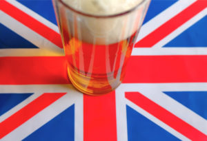 Pint of beer sitting on the flag of Great Britain. 